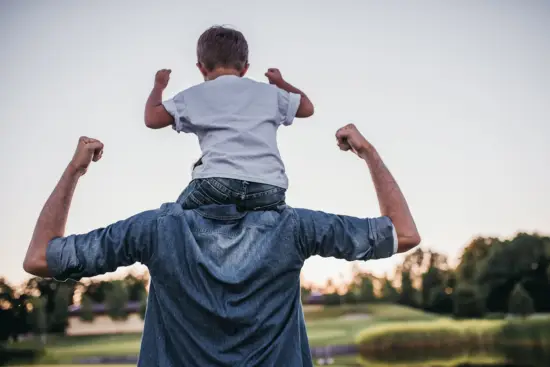 Vater trägt Sohn auf den Schultern