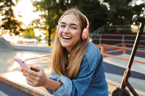 Studentin mit Smartphone und Kopfhörern